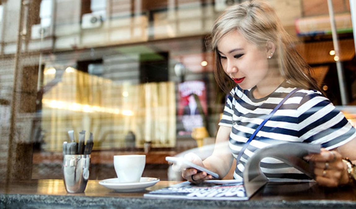 Young female on her mobile while sitting at a cafe